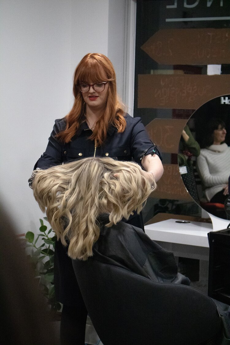 Hairdresser showing customer final blonde curly haircut