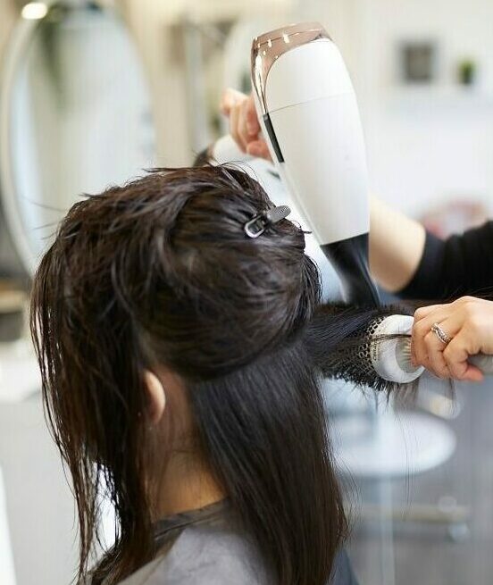 Customer having hair blow dried