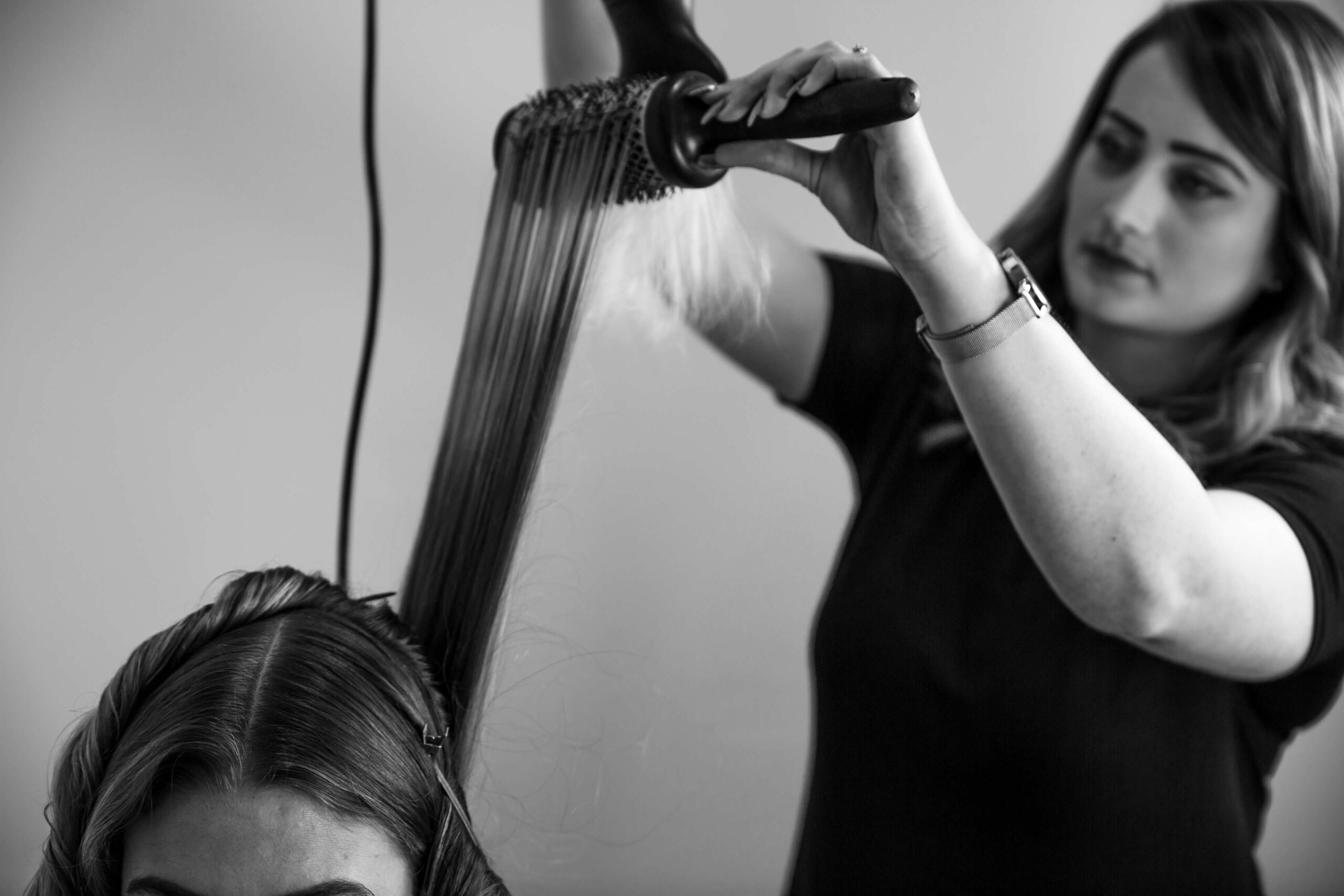 Hairdresser blow-drying hair