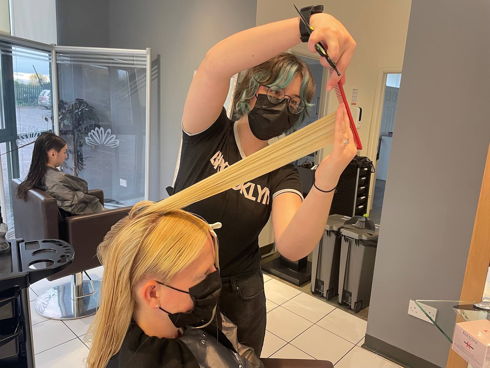 Woman having long hair cut