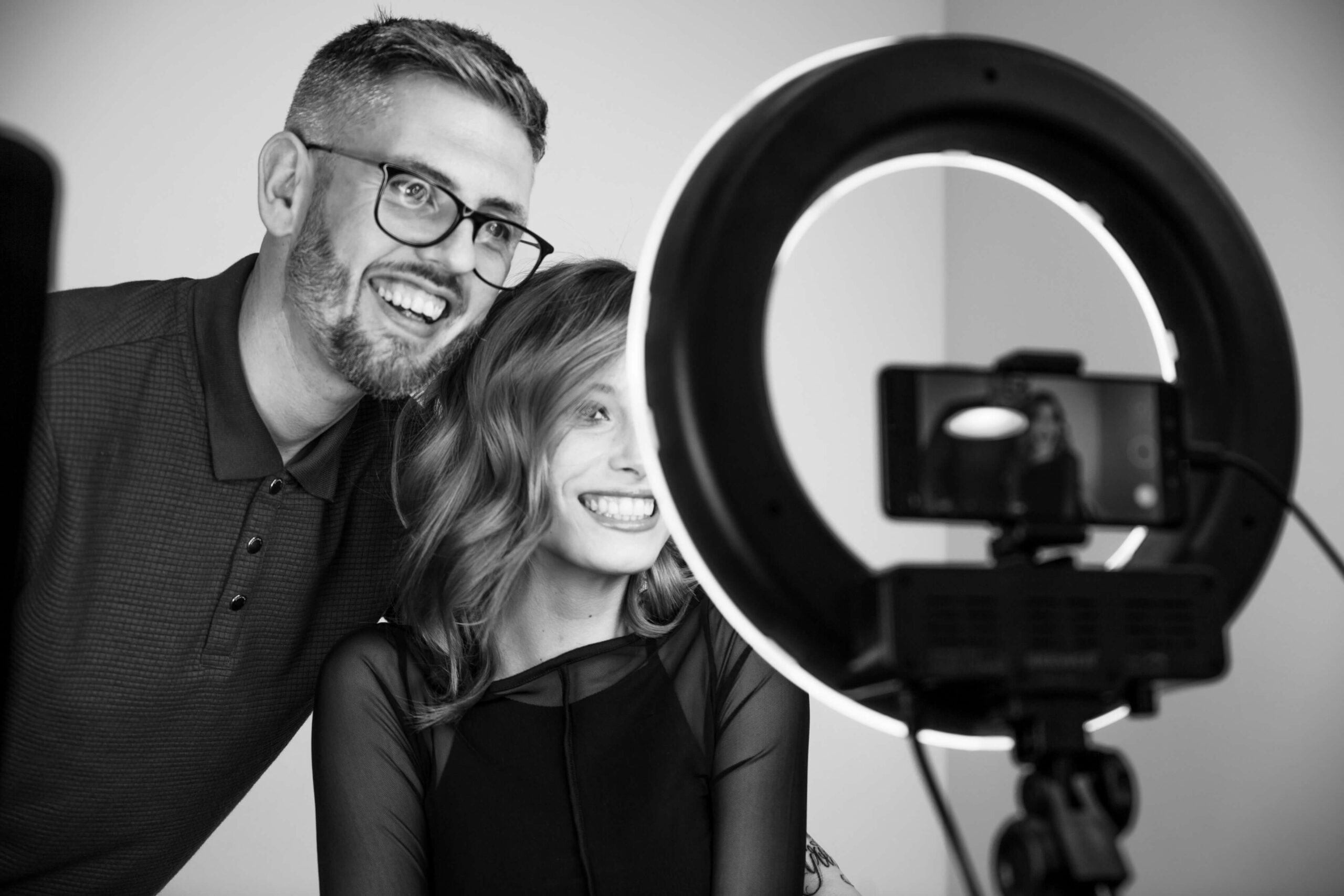 Hairdresser and customer smiling with finished haircut