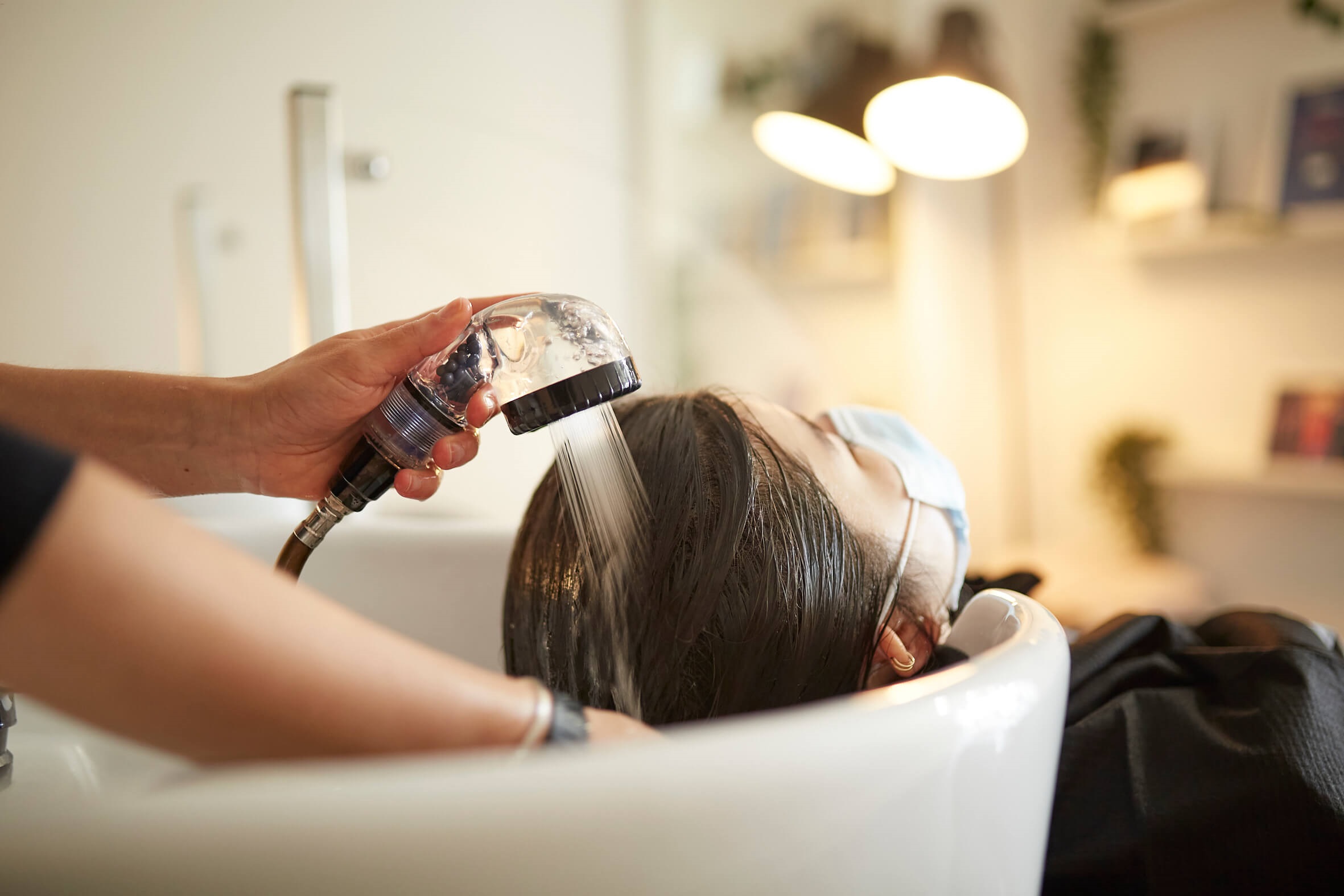 Woman having treatment in salon basin