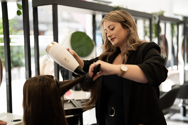 Corey Taylor blow drying a client's hair at NOCO Hair Bristol